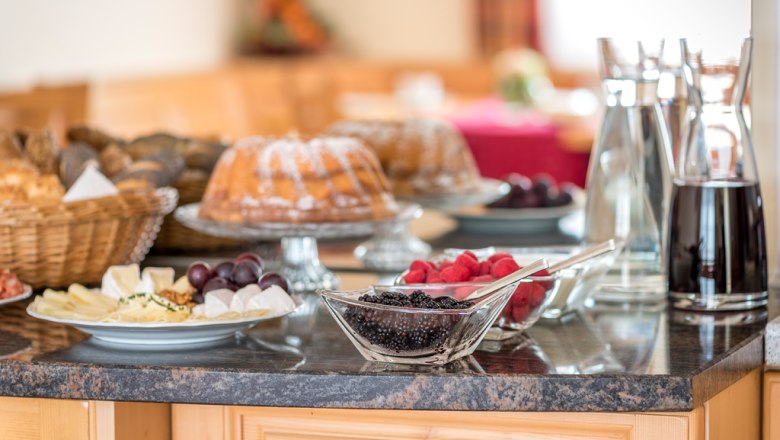 Frühstück, © Fam. Breitenfelder Frühstücksbuffet mit Kuchen, Beeren, Käseplatte und Getränken auf einem Tisch.