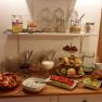 Frühstück, © Familie Fleischmann Ein Frühstücksbuffet mit Obst, Brot, Aufstrichen und Müsli in einem gemütlichen Raum.