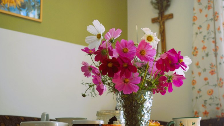 Weinbauernhof Löscher, Esszimmer, © Christina Löscher Ein Frühstückstisch mit Blumenstrauß, Marmelade, Honig und Geschirr.