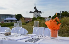 Tafeln im Weinviertel, © Weinviertel Tourismus GmbH Gedeckter Tisch im Freien mit Windmühle im Hintergrund.