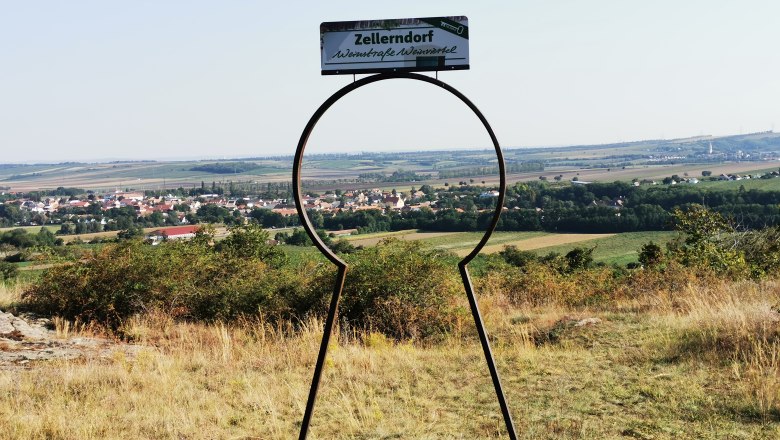 Das Schlüsselloch weist auf die Schönheit der Region hin, © Weinstraße Weinviertel Blick auf Zellerndorf durch eine schlüsselförmige Metallskulptur.