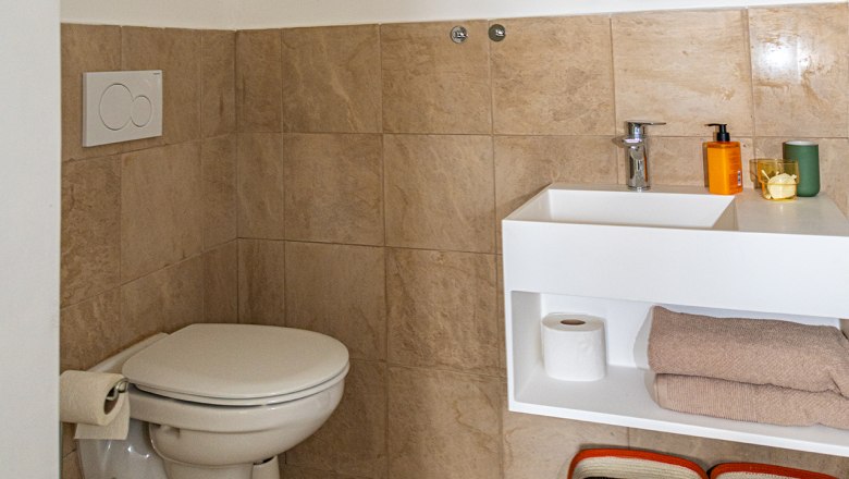 Badezimmer und WC, © Fam. Heichinger Modernes Badezimmer mit WC, Waschbecken, Spiegel und Ablageflächen.