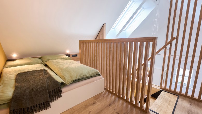 Wiegehaus, © Bernhard Raab Modernes Schlafzimmer im Dachgeschoss mit Holzgeländer und Dachfenstern.