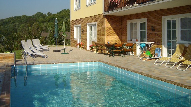 Pension Rudi, © Pension Rudi Außenansicht einer Pension mit Pool und Liegestühlen.