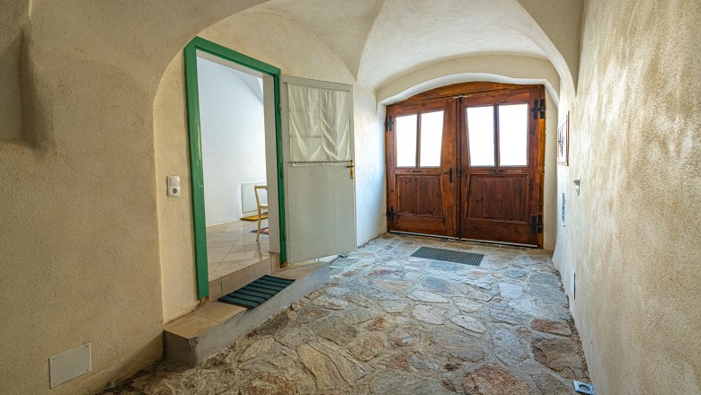 Eingangsbereich, © Fam. Heichinger Eingangsbereich mit Holztüren und Steinboden.