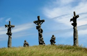 Kalvarienberg Pillersdorf, © Franz Tröthan Drei Kreuze mit Figuren auf einem Hügel unter blauem Himmel.