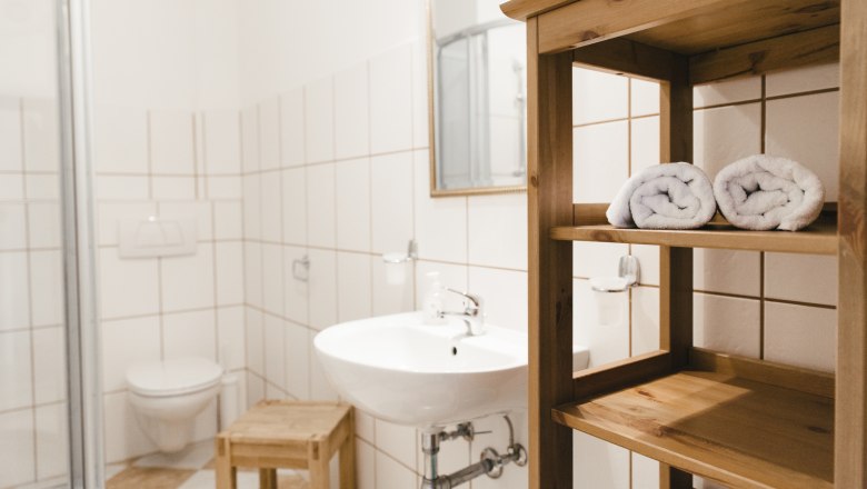 Badezimmer, © Agnes Buchmayer Modernes Badezimmer mit Waschbecken, Handtüchern und Dusche.