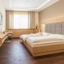 Gästezimmer, © Fam Breitenfelder / Podolsky Modernes Gästezimmer mit Doppelbett, Flachbildfernseher und Holzmöbeln.