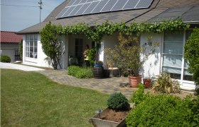 Garten, © Fam. Gaida Haus mit Solarpanelen und Garten im Vordergrund.