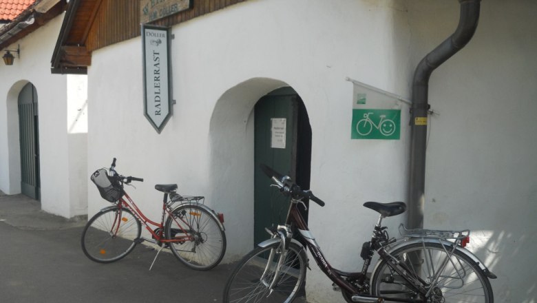 Rastplatz Kellergasse, © Peter Mödl Zwei Fahrräder vor einem Gebäude mit der Aufschrift 'Weinbau Radlerrast'.