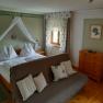 Gästezimmer, © Familie Fleischmann Gemütliches Gästezimmer mit Doppelbett, Sofa und Holzmöbeln.