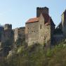 Burg Hardegg auf einem H&uuml;gel mit B&auml;umen im Vordergrund.