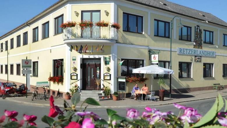 Retzerlandhof, © Herbert Schleich Außenansicht des Retzerlandhofs mit Terrasse und Blumen.