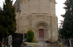 Karner Pulkau, ein historisches Gebäude mit spitzem Dach, umgeben von einem Friedhof.