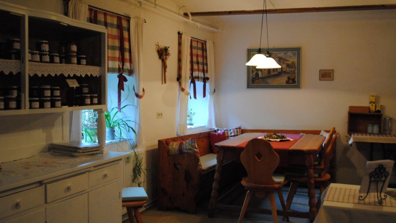 Gemütliche Küche mit Holzmöbeln und karierten Vorhängen.