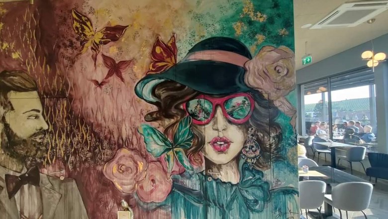 Wandgemälde mit stilisierten Porträts eines Mannes und einer Frau in einem Café.