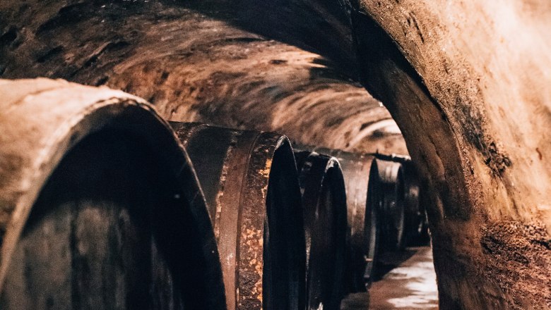 Ein alter Weinkeller mit gro&szlig;en Holzf&auml;ssern an den W&auml;nden.