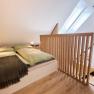 Modernes Schlafzimmer im Dachgeschoss mit Holzgel&auml;nder und Dachfenstern.