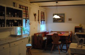 Gemütliche Küche mit Holzmöbeln und karierten Vorhängen.