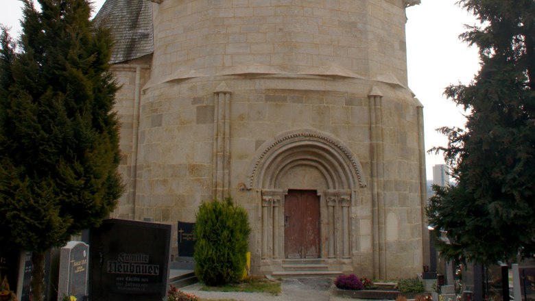 Karner Pulkau, ein historisches Geb&auml;ude mit spitzem Dach, umgeben von einem Friedhof.