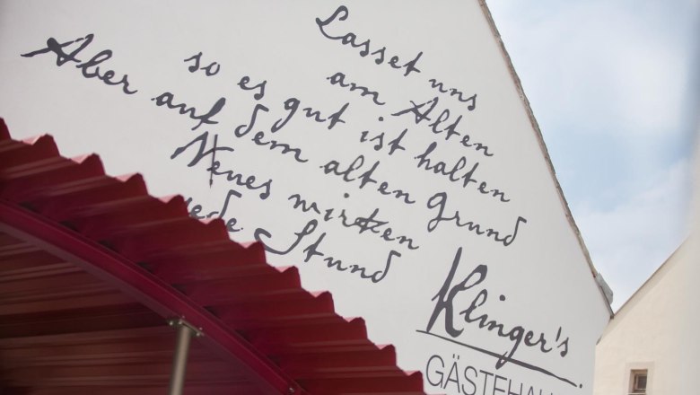 Fassade von Klinger's Gästehaus mit handgeschriebener Inschrift und rotem Vordach.