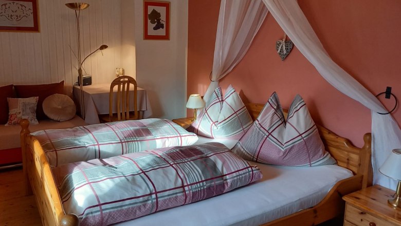 Gemütliches Gästezimmer mit Doppelbett, Nachttischlampen und Schreibtisch.