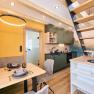 Modernes Interieur eines kleinen Hauses mit K&uuml;che, Esstisch und Treppe.